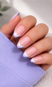 Short almond nails with pastel French tips in soft pink and lavender tones with glossy finish and natural lighting